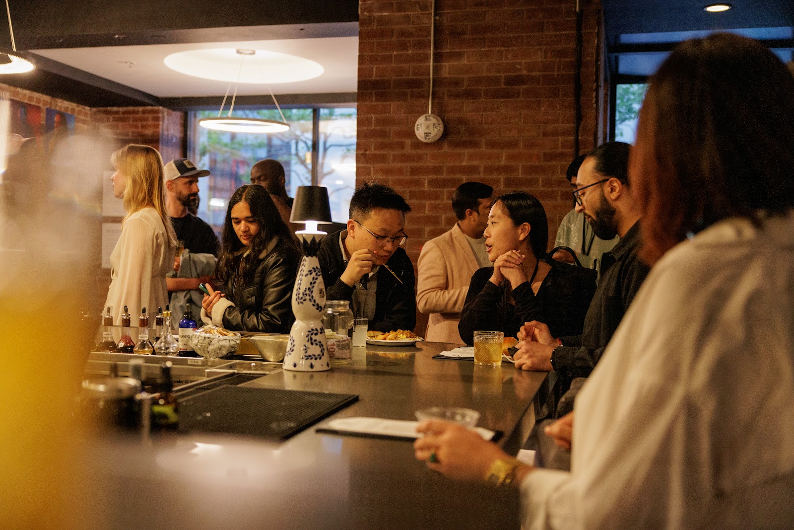 Dynamism guests gathered around the bar over food and drinks.