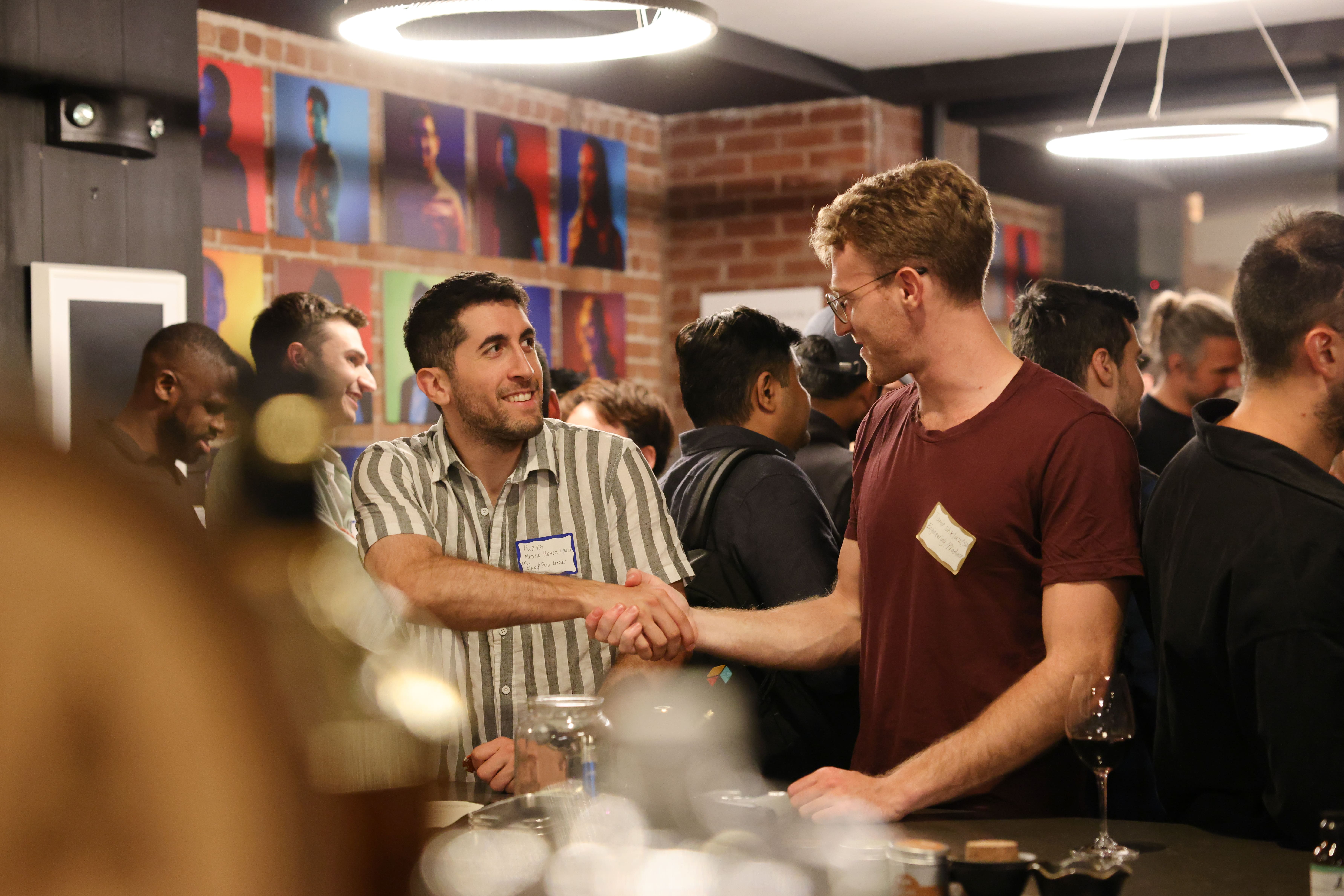 Guests talking and shaking hands at a Dynamism gathering.