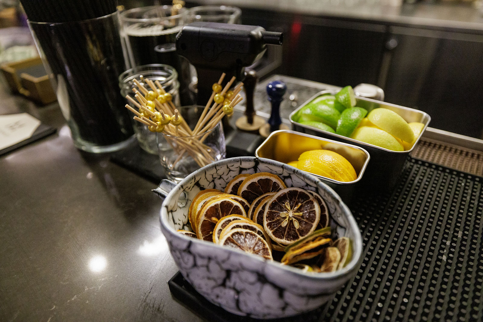 Citrus garnishes, bottles and drinks at the event bar.
