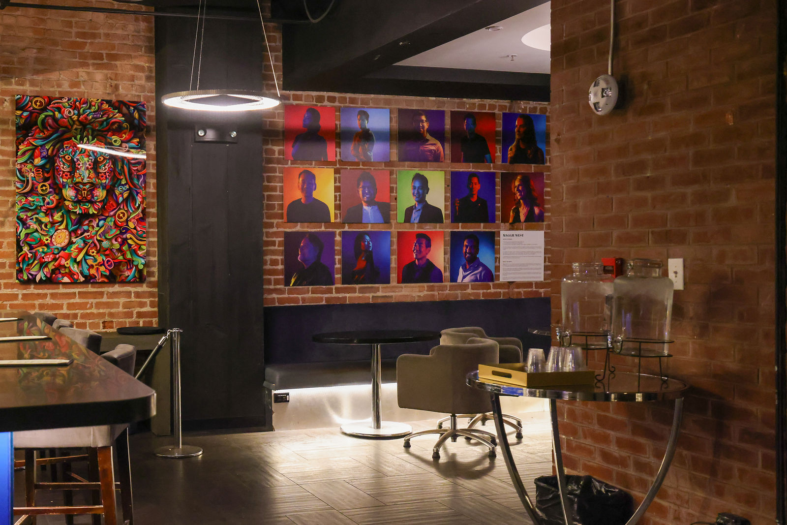 The gathering space with art on the brick walls, lounge seating and ring pendant lights.